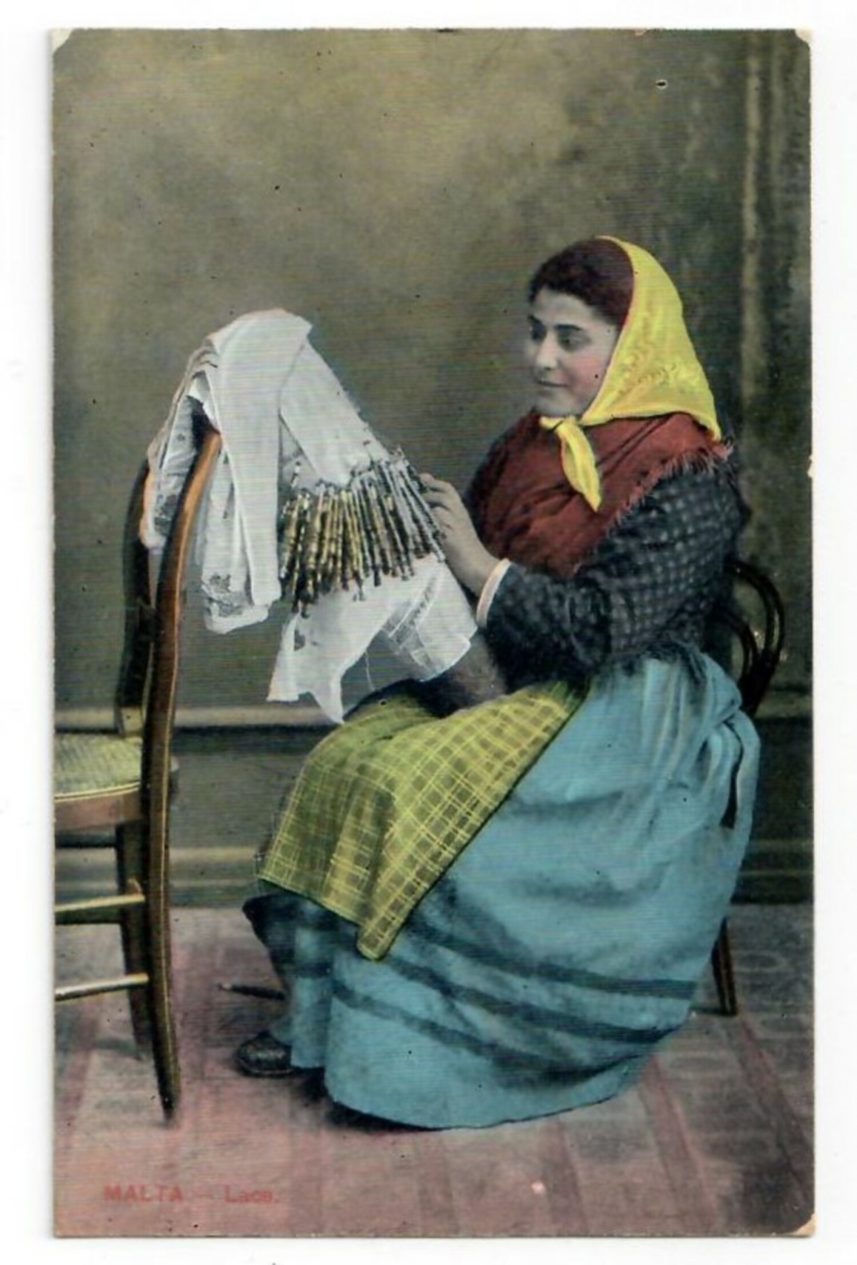 A Maltese lace maker at work using an upright pillow with numerous long, thin wooden bobbins (early 20th century).
