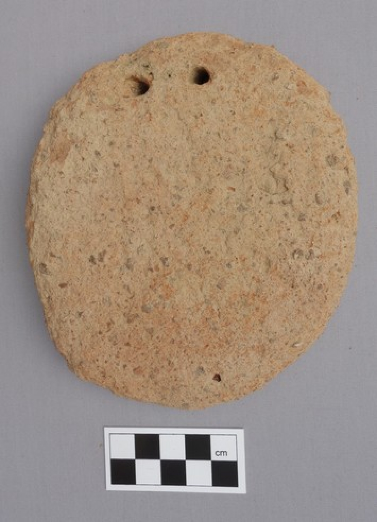 Ancient Greek disk-shaped loom weight, made of clay.