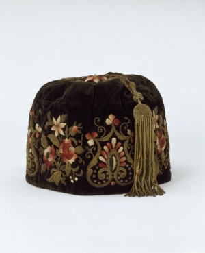 A smoking cap from the 1860&#039;s, made in South America for the Portuguese market. It is made from embroidered velvet and lined with silk, the long tassel is also of silk