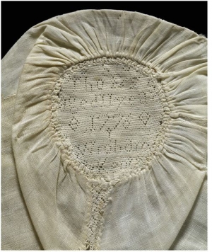 A late 18th century linen child’s cap decorated with a band of hollie point