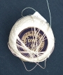 Ball of thread with a paper pattern stuck inside. DMC, 1920s-1940s.