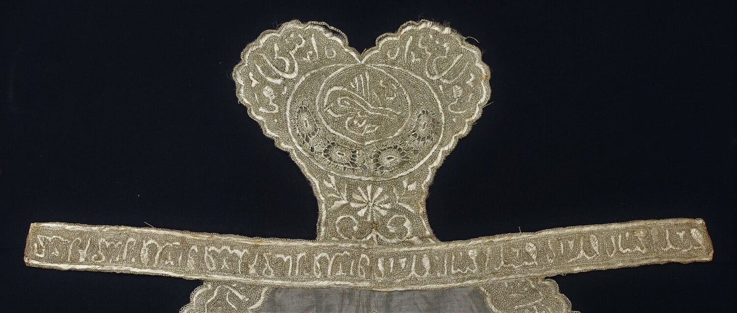 Detail of the Ottoman Turkish apron with a text (?) in Arabic script, 19th century (TRC 2003.0199).