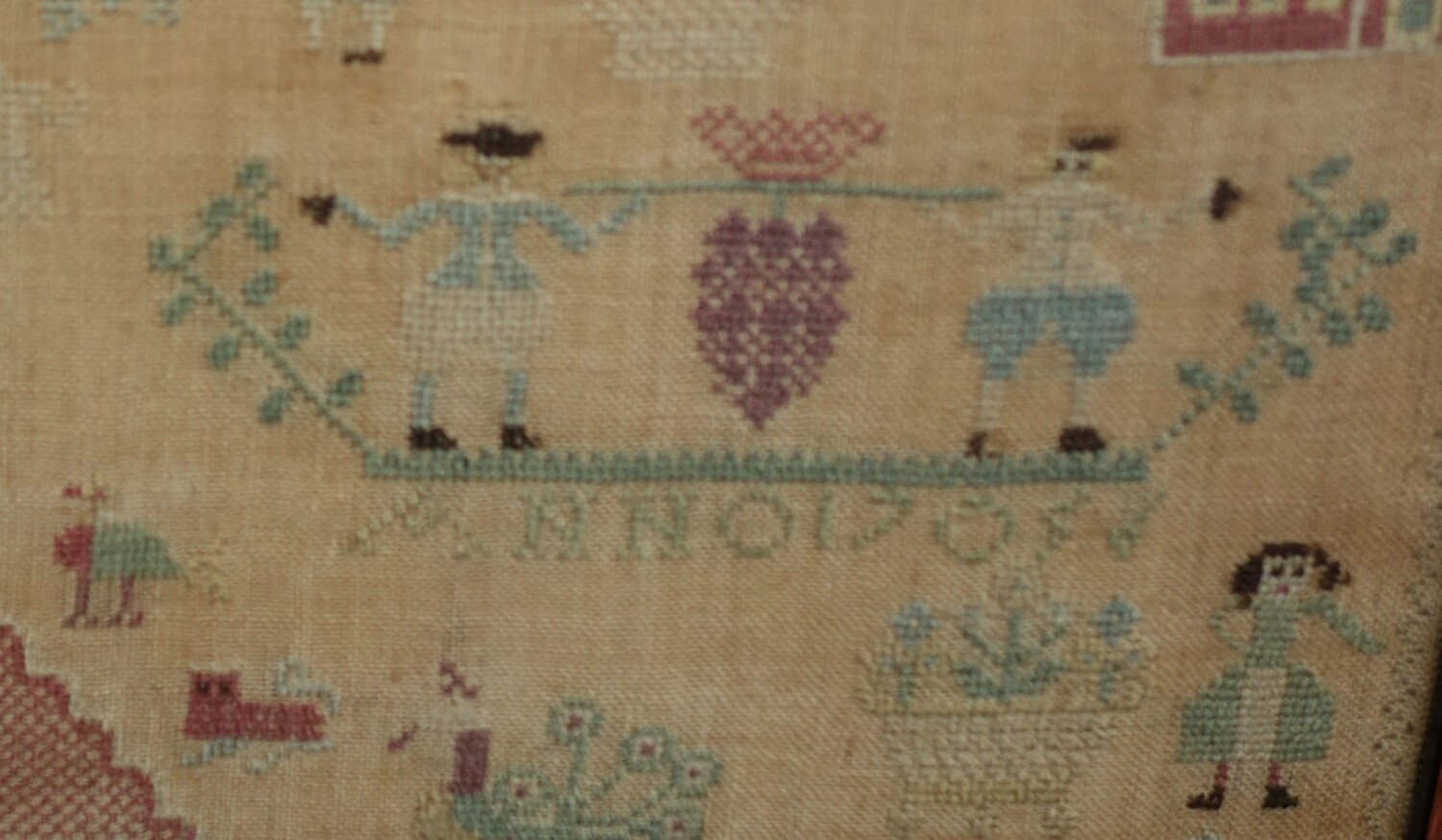 Detail of sampler TRC 2020.3683, with an embroidered illustration of the two Israelites returning from the Promised Land.