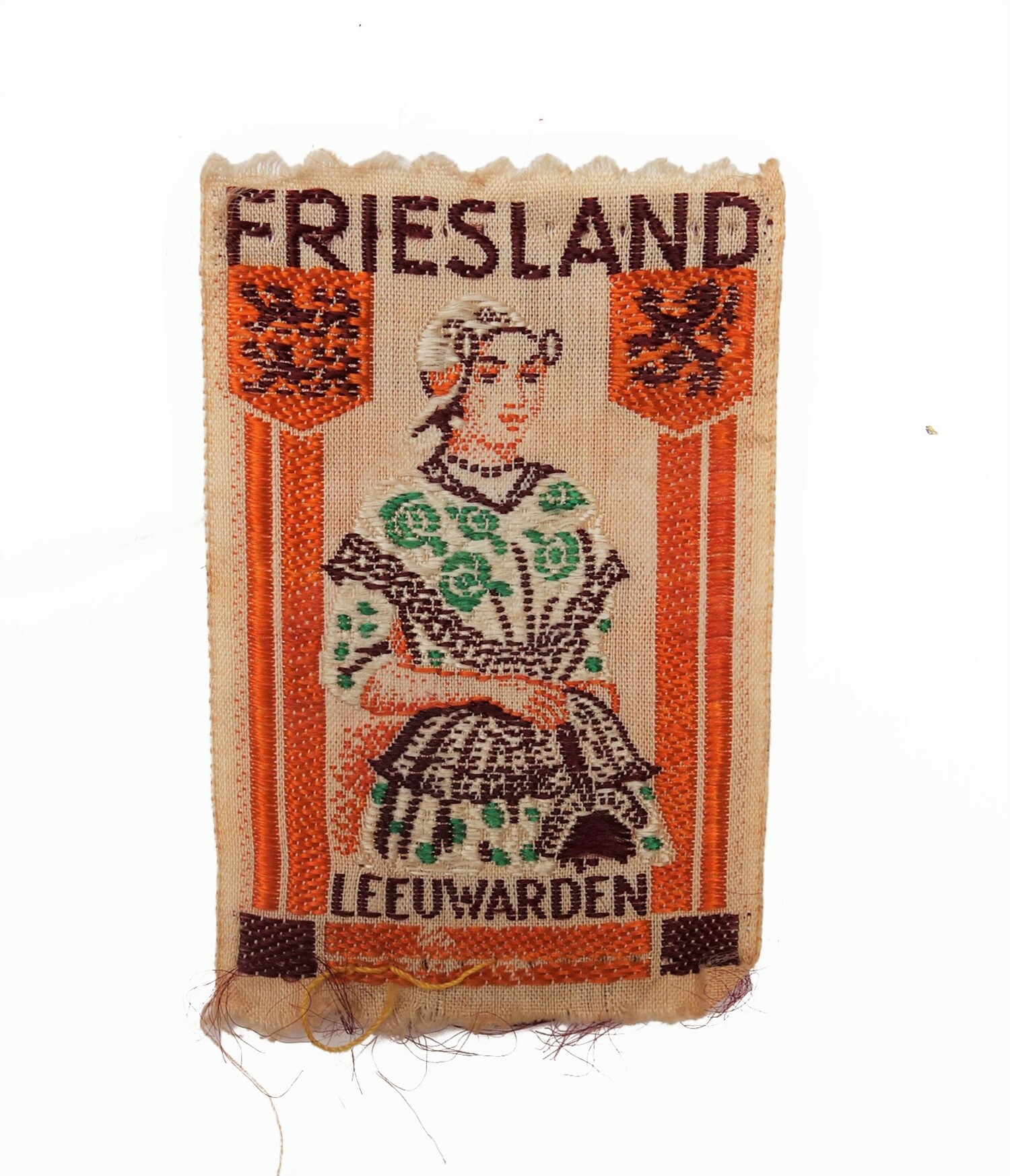 Cloth badge with the woven image of a woman from Friesland, the Netherlands, in regional dress. 20th century (TRC 2021.2018d).