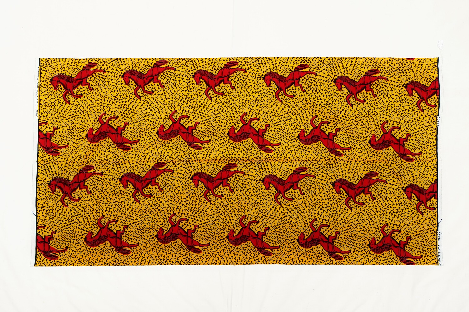 Length of cloth with an overall design of prancing dark red and black horses on a yellow ground with black Y-shapes scattered on it. There are several selvedge texts that state: "VERITABLE WAX HOLLANDAIS VLISCO", "GUARANTEED DUTCH WAX VLISCO" and "53500". The Netherlands, 2022 (TRC 2022.2262).