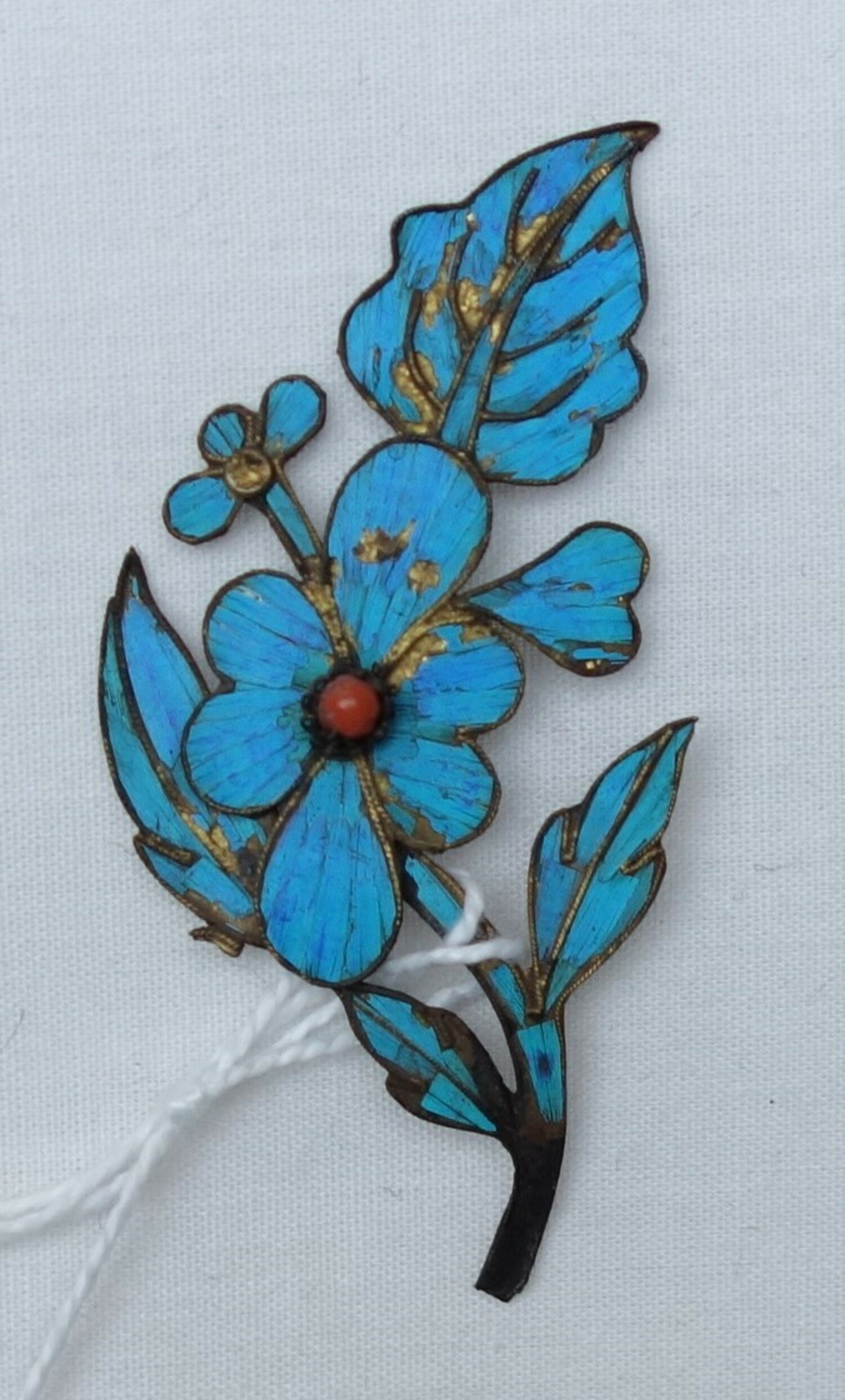Hair pin in the shape of a small sprig of flowers and leaves, with kingfisher feather decoration, China, 20th century (TRC 2023.2526).