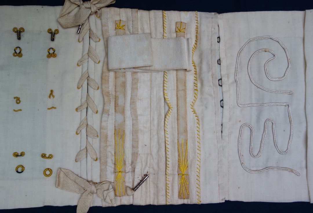 Detail of the corset sample with lacing, boning, flossing and hooks and eyes (TRC 2023.2780).