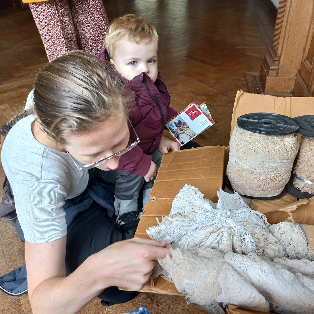 Mother and son looking at a collection of lace, donated to the TRC by the former owners of Boerhaavelaan 6.