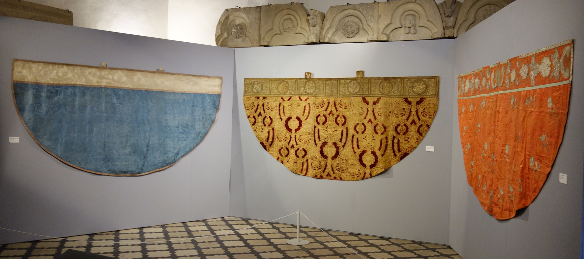 Three elaborately decorated, silk copes, on display in the Cluny Museum.