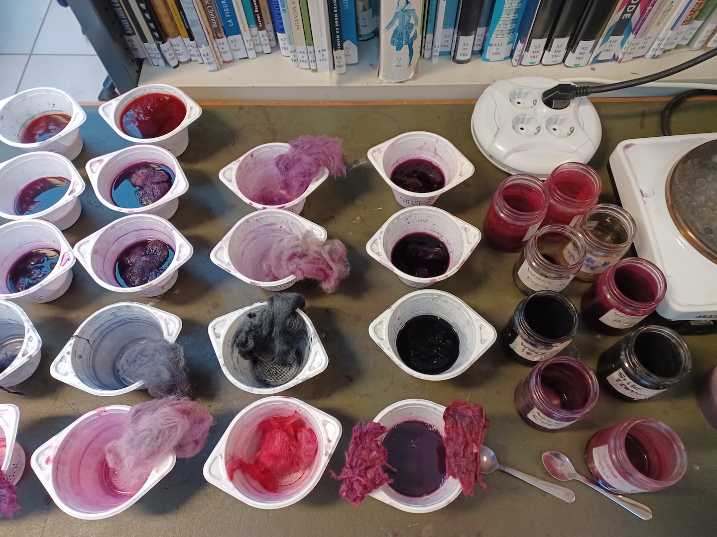 Dyeing experiments with different types of fibres in cochineal-and-mordant solution. Photograph by author.